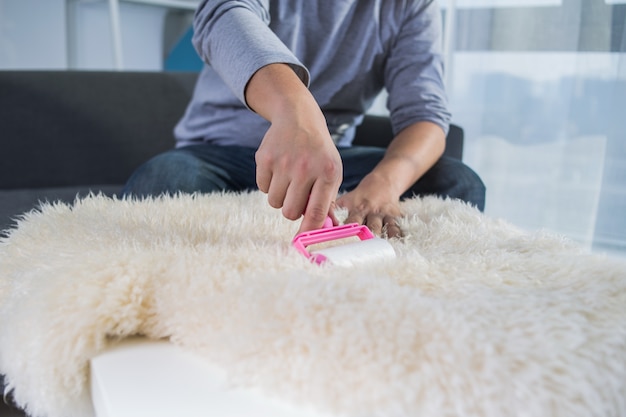 Free photo adhesive roller for cleaning sheepskin rug. lint roller with pink handle.