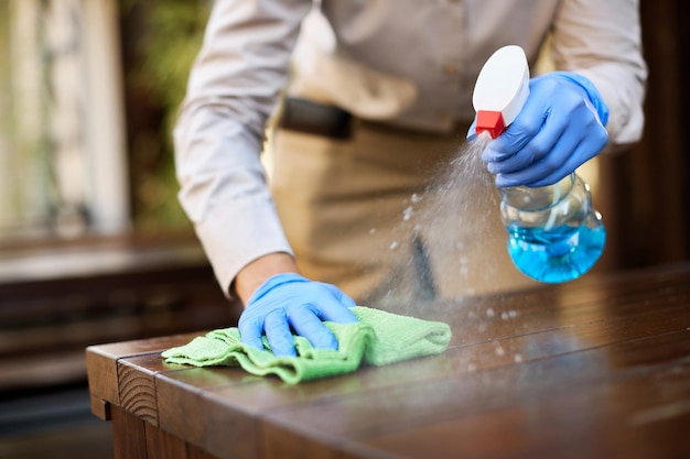 Free photo closeup of waitress disinfecting tables at outdoor cafe