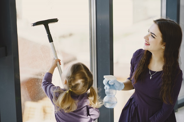 Free photo daughter and mother cleaning window together