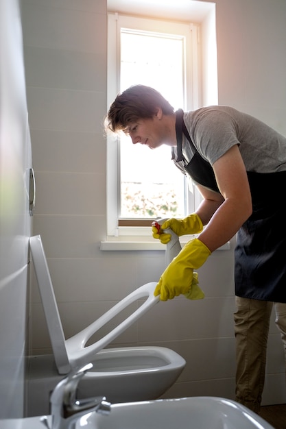 Free photo man servant cleaning the house