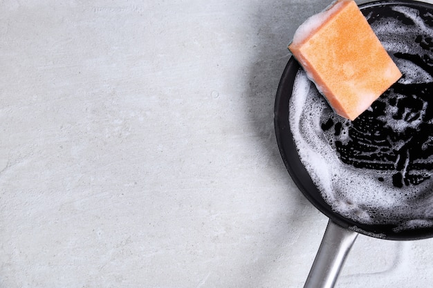 Free photo sponge washing a pan