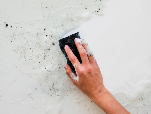 Free photo top view of hand scrubbing dirt with sponge
