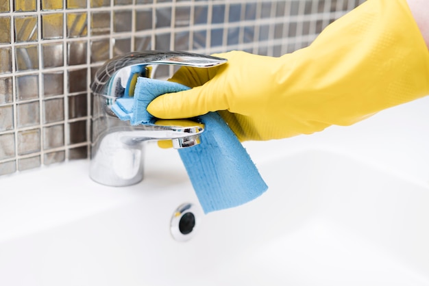 Free photo woman cleaning sink in the bathroom