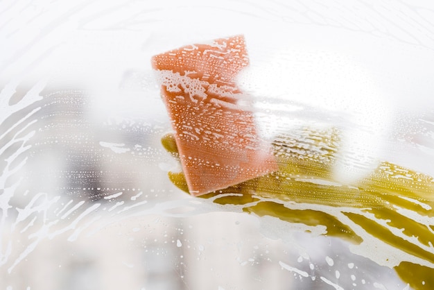 Free photo woman cleaning window with sponge