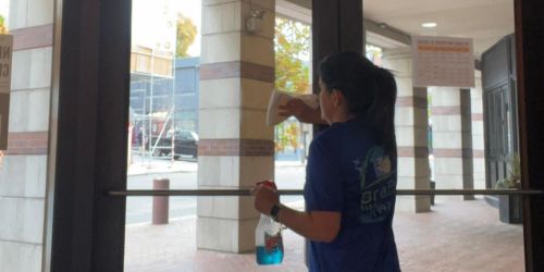 BraBos Cleaning team member cleaning glass doors at a Boston office entrance