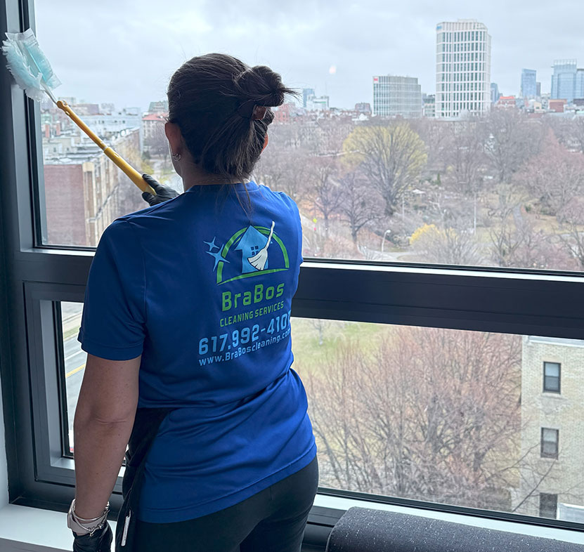 Brabos Cleaning staff member dusting windows as part of a customizable cleaning service in Boston