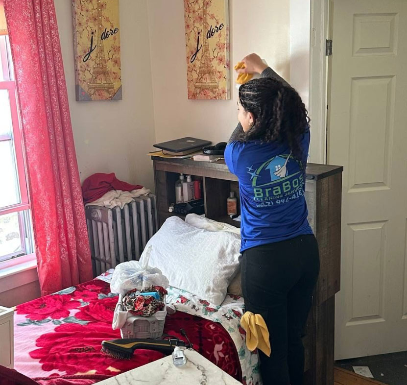 Brabos Cleaning staff member cleaning a bedroom in a Boston home